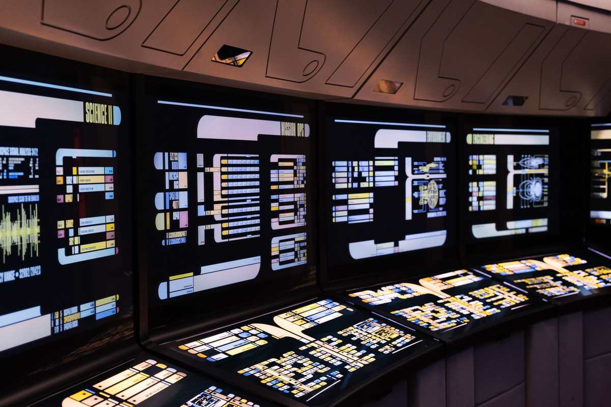 Vue d'une console de contrôle avec écrans lumineux et panneaux interactifs